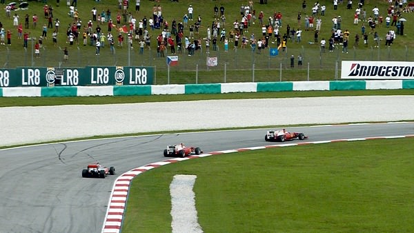 A scattering of fans watch the Malaysian Grand Prix from the banking.