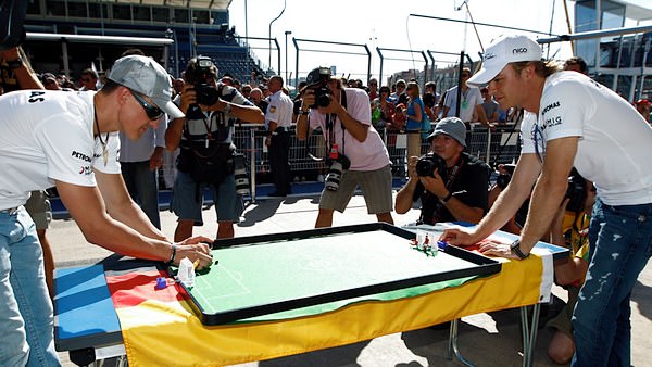 Schumacher challenges Rosberg to a game of Tipp-Kick football in the F1 paddock.