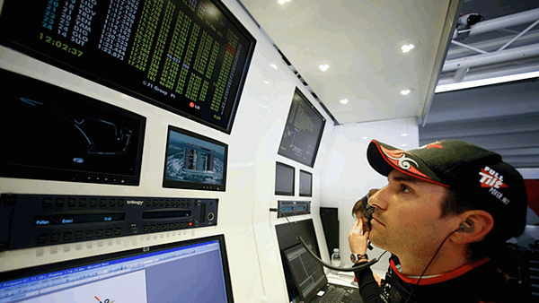 Timo Glock studies the live timing screens in the Virgin Garage during Friday practice at Hockenheim