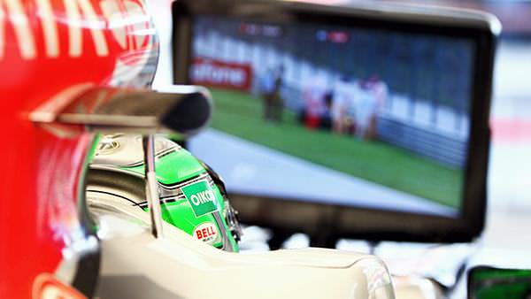 Liuzzi watches on the monitor as Vettel's damaged car is recovered during Free Practice 1